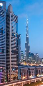 a city skyline with tall buildings and a bridge at Carlton Downtown Hotel in Dubai