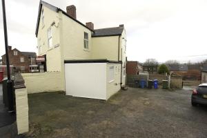 a large white garage in the side of a house at 55A Derbyshire Lane in Sheffield