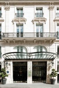 ein weißes Gebäude mit Balkon darüber in der Unterkunft La Maison Champs Elysées in Paris