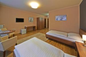 a bedroom with a bed and a table and a desk at Penzion Club in Skalica