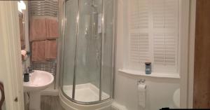 ein Bad mit einer Dusche und einem Waschbecken in der Unterkunft SmallBrook Cottage in Broadway