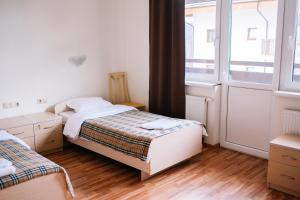 1 dormitorio con 2 camas y ventana en Priyut Pandy, en Estosadok