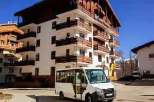 una pequeña furgoneta blanca estacionada frente a un edificio en Priyut Pandy, en Estosadok