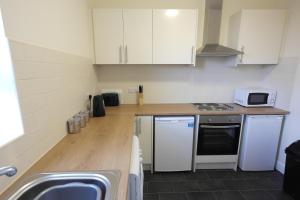 a small kitchen with white cabinets and a sink at 55A Derbyshire Lane in Sheffield