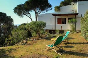 una silla y una mesa frente a una casa en Scaglieri Mare by ArgonautiVacanze, en Portoferraio