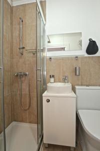 uma casa de banho com um chuveiro, um lavatório e um WC. em my lovely Alfama's studios em Lisboa