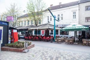 una cafetería al aire libre con mesas, sillas y sombrillas en Motel Korzo, en Bihać