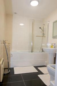 a bathroom with a shower and a tub and a sink at Coppice Cottage in Grantown on Spey