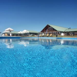 una gran piscina de agua azul frente a un edificio en Los Naranjos Resort & Spa Termal, en Termas del Daymán