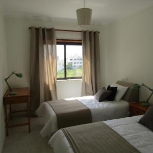 a hotel room with two beds and a window at Apartamento Turf in Alvor