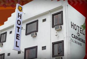 un bâtiment blanc avec des fenêtres et un panneau sur celui-ci dans l'établissement Hotel D´ Carmona, à Ciudad Valles