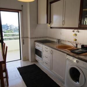 een keuken met een spoelbak en een wasmachine bij Apartamento Turf in Alvor