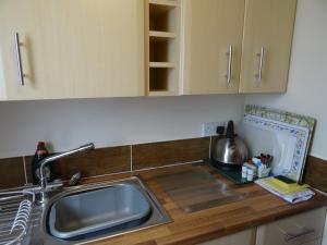 a kitchen with a sink and a counter top at Victoria Lodge in Sandown