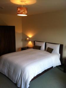 a bedroom with a large white bed with two lamps at All the Twos Lodge in Clifden +15 photos