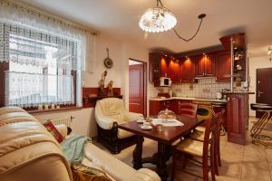 a living room with a table and a kitchen at Apartamenty Okowita i Karat Zakopane in Zakopane