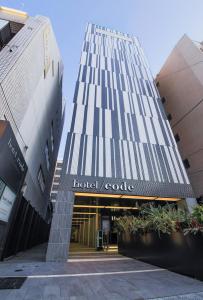 ein hohes Gebäude mit einem Hotel-Google-Schild darauf in der Unterkunft Hotel Code Shinsaibashi in Osaka