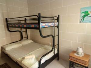 two bunk beds in a room with a table at Coral Reef Flat 7 in Marsalforn