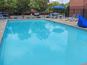 une grande piscine bleue avec des chaises et un parasol dans l'établissement Extended Stay America Suites - Atlanta - Vinings, à Atlanta