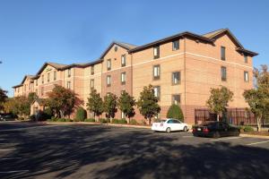 un grand bâtiment en briques avec des voitures garées dans un parking dans l'établissement Extended Stay America Suites - Atlanta - Vinings, à Atlanta