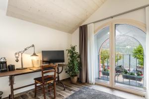 ein Büro mit einem Schreibtisch mit einem Computer und einem Fenster in der Unterkunft La Locanda del Cantiere in Laglio