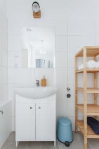a white bathroom with a sink and a shelf at Apartamenty Krakowskie 36 Lublin - Single Two in Lublin