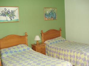 two beds in a bedroom with green walls at El Capistrano Sur in Nerja