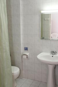 a bathroom with a sink and a toilet and a mirror at Elarin studios & apartments in Faliraki +48 photos