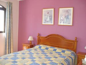 a bedroom with a bed and two pictures on the wall at El Capistrano Sur in Nerja