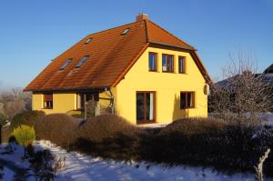 una casa amarilla con techo marrón en Ferienwohnungen Arkonablick, en Lohme