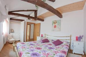 a bedroom with a bed with a floral bedspread at Appartamento Calle dei Preti info at yourhomefromhomeinvenice-venicerentalapartments dot it in Venice