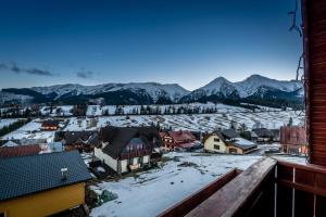 uitzicht op een stad met besneeuwde bergen bij Penzión u Pavla in Ždiar