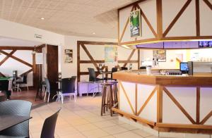 a restaurant with a bar with chairs and tables at VVF Plaine d'Alsace Obernai Strasbourg in Obernai