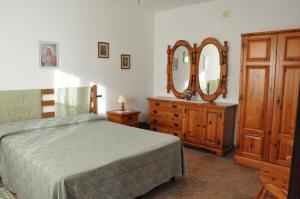 une chambre avec un lit et une commode avec un miroir dans l'établissement Agriturismo Magnaboschi, à Alberese 15 autres photos