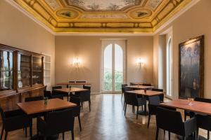 a dining room with tables and chairs and a ceiling at Villa Pulejo in Messina