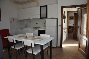 - une cuisine avec une table blanche et des appareils électroménagers blancs dans l'établissement Agriturismo Magnaboschi, à Alberese