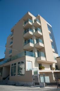 リミニにあるResidence Hotel Albachiaraの青空前のアパートメント ビル