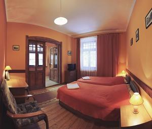 シフィエラドゥフ・ズドルイにあるPensjonat Eldoradoのベッド2台とデスクが備わるホテルルームです。