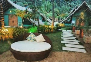 a wicker couch sitting in front of a house at Buko Beach Resort in El Nido