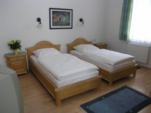 two twin beds in a room with at Landgasthof und Hotel Forchhammer in Pliening