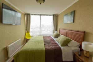 a bedroom with a bed and a large window at EcoApart Concepción in Concepción