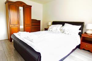 ein Schlafzimmer mit einem großen weißen Bett und einer Holzkommode in der Unterkunft Coppice Cottage in Grantown on Spey