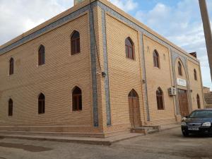 a brick building with a car parked in front of it at Islambek Hotel & Travel in Khiva