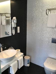 La salle de bains est pourvue d'un lavabo blanc et de toilettes. dans l'établissement Hotel Do Chile, à Lisbonne