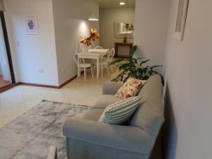 sala de estar con sofá y mesa en Flora Apartments en Puerto Iguazú