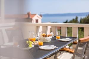 a table with food and drinks on a balcony at Apartments Biserka in Bol