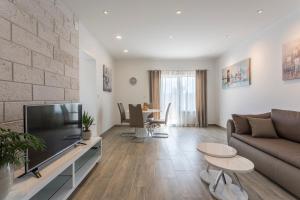 a living room with a couch and a tv at Apartments Biserka in Bol