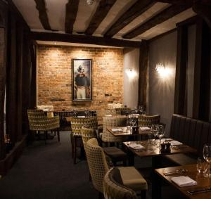 莫尔登The Swan Hotel Bar and Grill的一间有桌椅和砖墙的餐厅