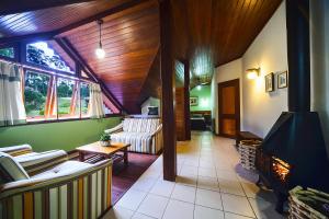 a living room with couches and a fireplace at Pousada dos Pinhos in Pedra Azul