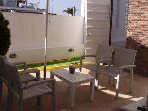 a patio with chairs and a table and an umbrella at Marine House Andrianna -Adults only in Siviri
