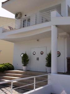 a white building with two eyes on the door at Marine House Andrianna -Adults only in Siviri
